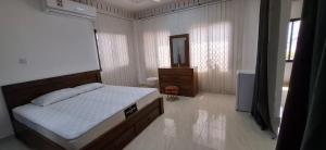 a bedroom with a bed and a dresser and a mirror at Waterfront in Muscat