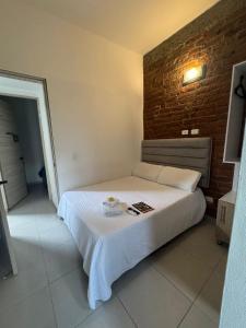 a bed in a room with a brick wall at HOTElES SAN ANTONIO in Cali