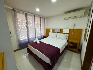 a bedroom with a large bed and a window at HOTElES SAN ANTONIO in Cali