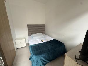 a small bedroom with a bed with a blue blanket at HOTElES SAN ANTONIO in Cali +3 photos