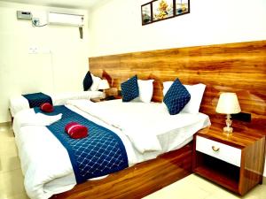 two beds in a hotel room with red and blue pillows at IRCTC Hotel HOSPET in Hospet