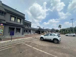a car parked in a parking lot in front of a building at IRCTC Hotel HOSPET in Hospet