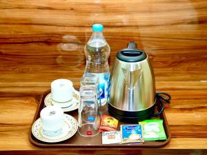 a tray with a tea kettle and cups on a table at IRCTC Hotel HOSPET in Hospet