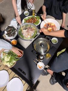 a group of people sitting around a table with food at KlomKlom garden home in Ban Tha Kham