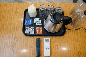 a table with a tray with a tea kettle and a remote control at Hidden Leaf in Dehradun