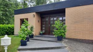 a brick building with potted trees in front of a door at Ferienhaus Waldblick in Zetel