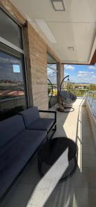 a living room with a blue couch on a balcony at Apartman CITY CENTER 9 BAZEN in Prijedor