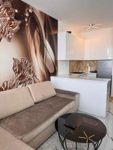 a living room with a couch and a kitchen at Apartman CITY CENTER 9 BAZEN in Prijedor