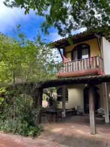 a house with a balcony and a patio at Vila Caribé in Lençóis