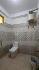 a bathroom with a toilet and a light on the wall at The Pine View in Kasol +15 photos