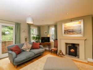 a living room with a couch and a fireplace at Ormiston House in Pewsey