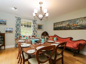 a dining room with a table and chairs and a couch at Ormiston House in Pewsey
