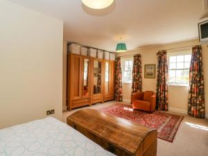 a bedroom with a bed and a couch and a chair at Ormiston House in Pewsey