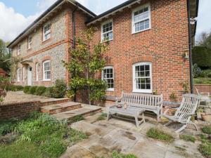 a brick house with a bench and a table at Ormiston House in Pewsey