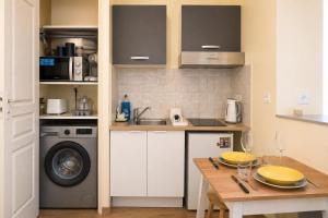 a kitchen with a table and a washing machine at Studio cosy & bien équipé in Brétigny-sur-Orge