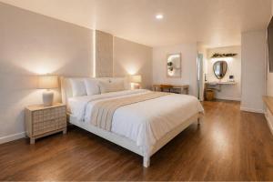 a bedroom with a large white bed and wooden floors at Forest Springs Resort in Eureka Springs +81 photos