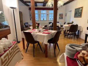 a dining room with a table and chairs with plates and dishes at Altstadthotel Wilde Rose in Eppingen