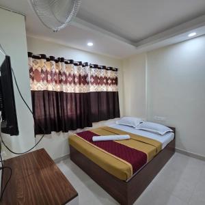 a bedroom with a bed and a television in it at Sumithra Palace in Bangalore