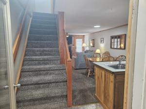 a staircase leading up to a living room and a kitchen at Powderidge 42 2 Br: Sleeps 10 in Snowshoe