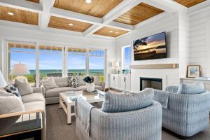 a living room with couches and a fireplace at Roosevelt Oceanfront Escape by Emerald Isle Realty in Pine Knoll Shores
