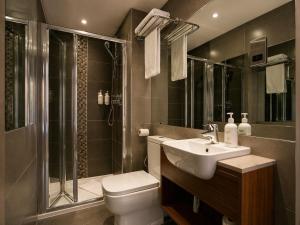 a bathroom with a toilet and a sink and a shower at London Court Hotel in London