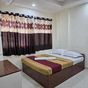 a bedroom with a large bed with a curtain at Sumithra Palace in Bangalore