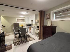 a bedroom with a bed and a kitchen with a table at Private Bachelor Suite Near PNE in Vancouver