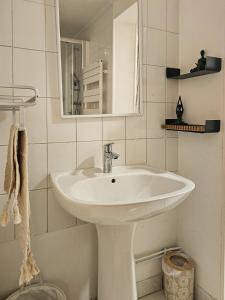 a white bathroom with a sink and a mirror at Le Michelet - Loft Cosy avec soirée cinéma Proche Vincennes in Montreuil