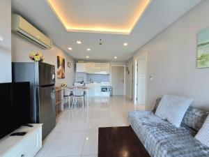 a living room with a couch and a kitchen at One Tower 84 by ThaiminatorPattaya in Pattaya South