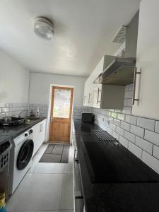 a kitchen with a sink and a stove top oven at Casa Azul in Plumstead +17 photos
