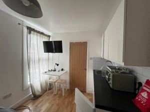 a small room with a kitchen with a table at Casa Azul in Plumstead