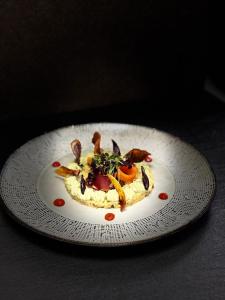 a white plate with food on a table at Hôtel Restaurant Le Rive Gauche in Joigny