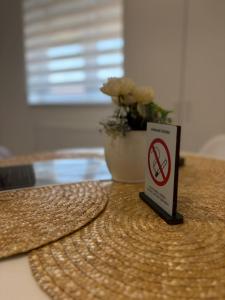 a no smoking sign sitting on a table with a plant at Apartman Diamond LUX in Surčin