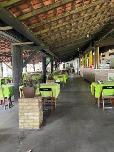 an empty restaurant with green tables and chairs at Samaúma Park Hotel in Barcarena