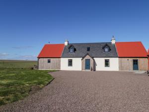 a barn with a red roof and a gravel driveway at The Mandrel in Tain