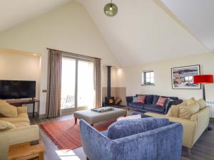 a living room with blue furniture and a large window at The Mandrel in Tain