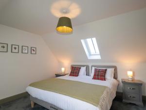 a bedroom with a bed with two night stands and two lamps at The Mandrel in Tain