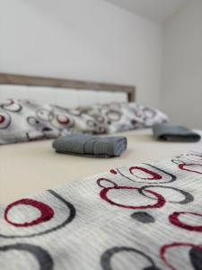 a blanket on a bed with a remote control on it at Apartman Diamond LUX in Surčin