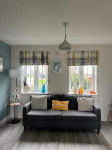 a living room with a couch and two windows at Murray's Lodge in Filey +26 photos