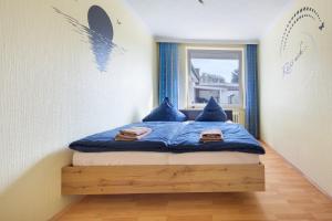 a bedroom with a bed with blue pillows and a window at Ferienhaus an der Luhe 150 M² in Winsen