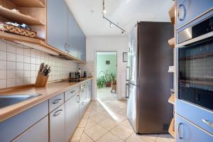 a kitchen with white cabinets and a stainless steel refrigerator at Ferienhaus an der Luhe 150 M² in Winsen