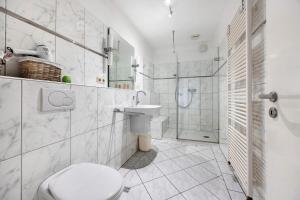 a white bathroom with a toilet and a shower at Ferienhaus an der Luhe 150 M² in Winsen +31 photos