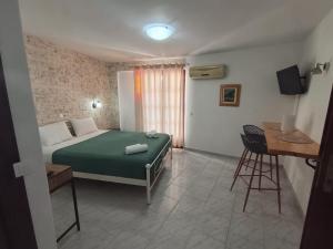 a bedroom with a bed and a table and a chair at Studios Loukia in Kokkari