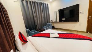 a hotel room with a bed and a tv at Vantara Premium, Haridwar- with swimming Pool in Haridwār