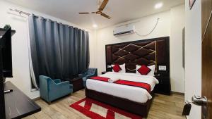 a bedroom with a large bed and a blue chair at Vantara Premium, Haridwar- with swimming Pool in Haridwār