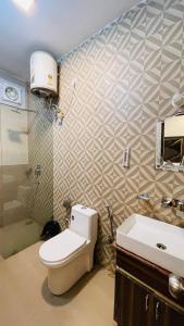 a bathroom with a toilet and a sink at Vantara Premium, Haridwar- with swimming Pool in Haridwār +22 photos