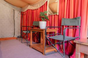 a group of chairs and a table in front of red curtains at Zero Degree Camps in Joshīmath