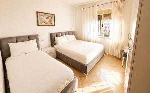 a bedroom with two beds and a window at H&G Seaview Apartments in Durrës