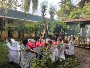 a group of people sitting around a table in a yard at Zebra guesthouse Hawassa in Āwasa