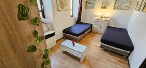 a small room with two beds and a table at Artist Apartment in Keszthely